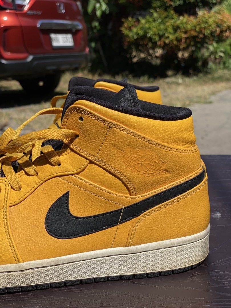 Air Jordan 1 Mid Taxi (Category: Sneakers) located in Los Banos. Submitted by ejb418 (Listing ID 1427647382, Image 2). Description: Air Jordan 1 Mid in a vibrant Taxi colorway. Features a yellow upper with black accents on the Swoosh, collar, and laces. The iconic Air Jordan wings logo is visible on the side. The size tag indicates a US size 11. The soles show some wear..