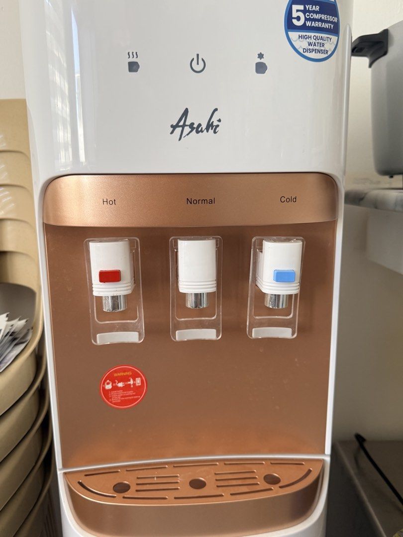 Asahi WD-108 Water Dispenser (Category: Water Purifiers & Dispensers) located in Naic. Submitted by nobletiger-d91e (Listing ID 1427645174, Image 1). Description: Asahi WD-108 water dispenser with hot, normal, and cold water options. Features a 5-year compressor warranty. The dispenser is white and rose gold in color. It has a top-loading design for water bottles. The model number is WD-108, and it operates on 230V/50 Hz. It has an on/off switch 