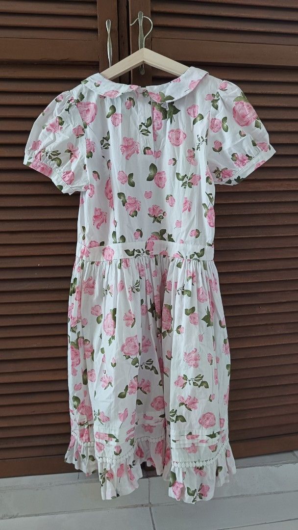 Boshira Floral Dress (Category: Dresses) located in Manila. Submitted by venus_se (Listing ID 1427645062, Image 2). Description: Dress features a charming floral print with pink roses on a white background. It has a round collar, short sleeves, and a gathered waist. The dress also has a ruffled hemline. The label indicates the brand is Boshira and the size is 160/60A(L)..