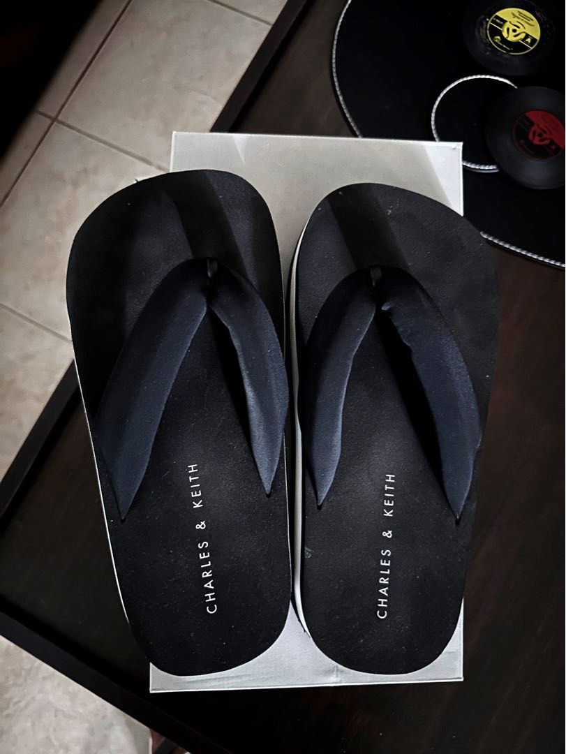 Charles & Keith Flip-flops (Category: Slippers and slides) located in Quezon City. Submitted by spatio (Listing ID 1408180499, Image 2). Description: - Black Charles & Keith flip-flops - Black footbed with brand name - Black straps - Wavy sole pattern - Comes with original box.