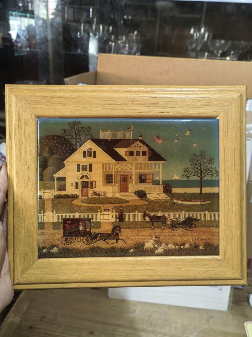 Decorative Ceramic Tile Wall Art Piece (Category: Wall Decor) located in Cebu City. Submitted by dudes_villanueva (Listing ID 1427641222, Image 2). Description: Decorative Ceramic Tile Wall Art Piece 📌Featuring folk art by Charles Wysocki, titled "Pickwick Cottage". 📌Artist: Charles Wysocki, known for Americana and pastoral scenes. 📌Scene: A colonial-style home by the sea with horse-drawn carriages. 📌Framing: The ceramic tile is encased in a 
