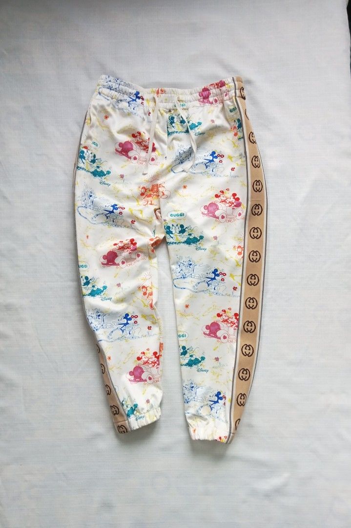 Disney x Gucci sidetape jogger pants (Category: Luxury Apparel) located in Bagabag. Submitted by thrift_stories96 (Listing ID 1427745148, Image 1). Description: Disney x Gucci sidetape jogger pants Small to medium frame Waistline - 28 to 32 Length - 35 Condition - excellent Flaw - missing washtag.