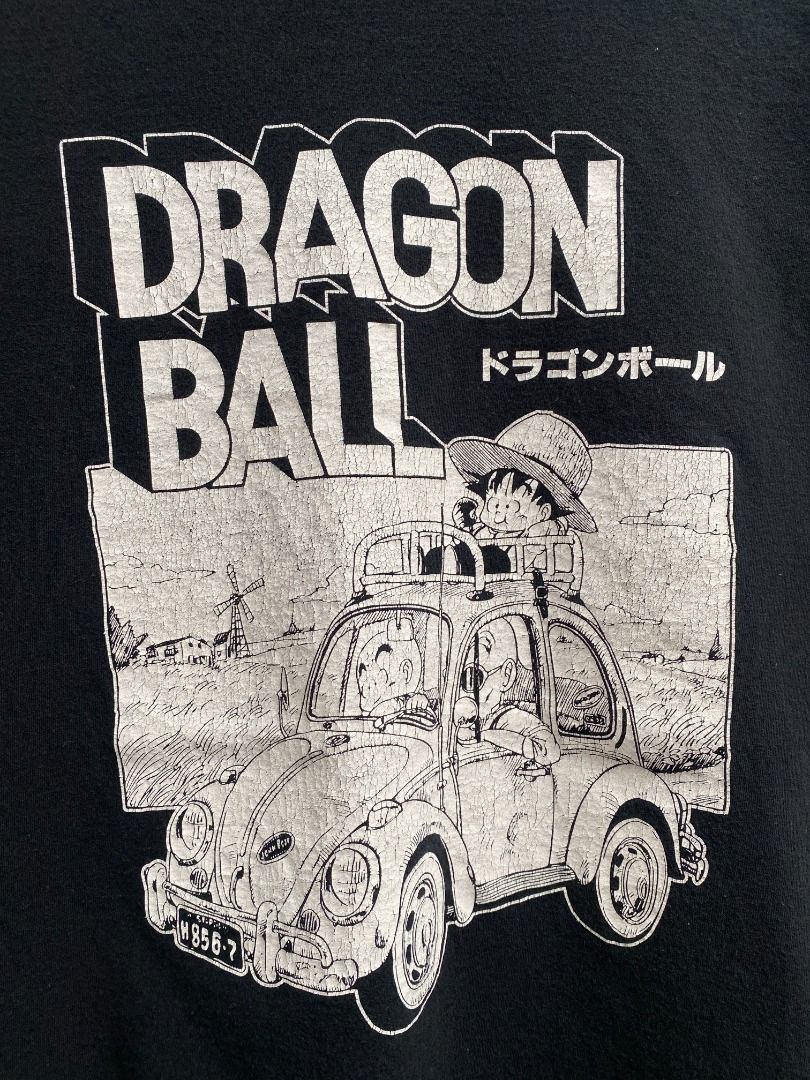 Dragon Ball Graphic Tee (Category: Tshirts & Polo Shirts ) located in Pasig City. Submitted by greatestpickup (Listing ID 1427678822, Image 2). Description: Black t-shirt featuring a Dragon Ball graphic. The graphic includes the words "Dragon Ball" in English and Japanese, along with an image of a vehicle. dbz volkswagen m on tag 19x27.5 500 .