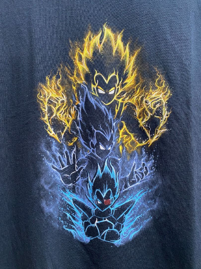 Dragon Ball Z Vegeta Graphic Tee (Category: Tshirts & Polo Shirts ) located in Pasig City. Submitted by greatestpickup (Listing ID 1427690615, Image 2). Description: Black t-shirt features a vibrant graphic of Vegeta in various Super Saiyan forms. The design showcases Vegeta with yellow and blue energy effects. The shirt has a classic crew neck design. dbz trio vegeta 25x30 2000.