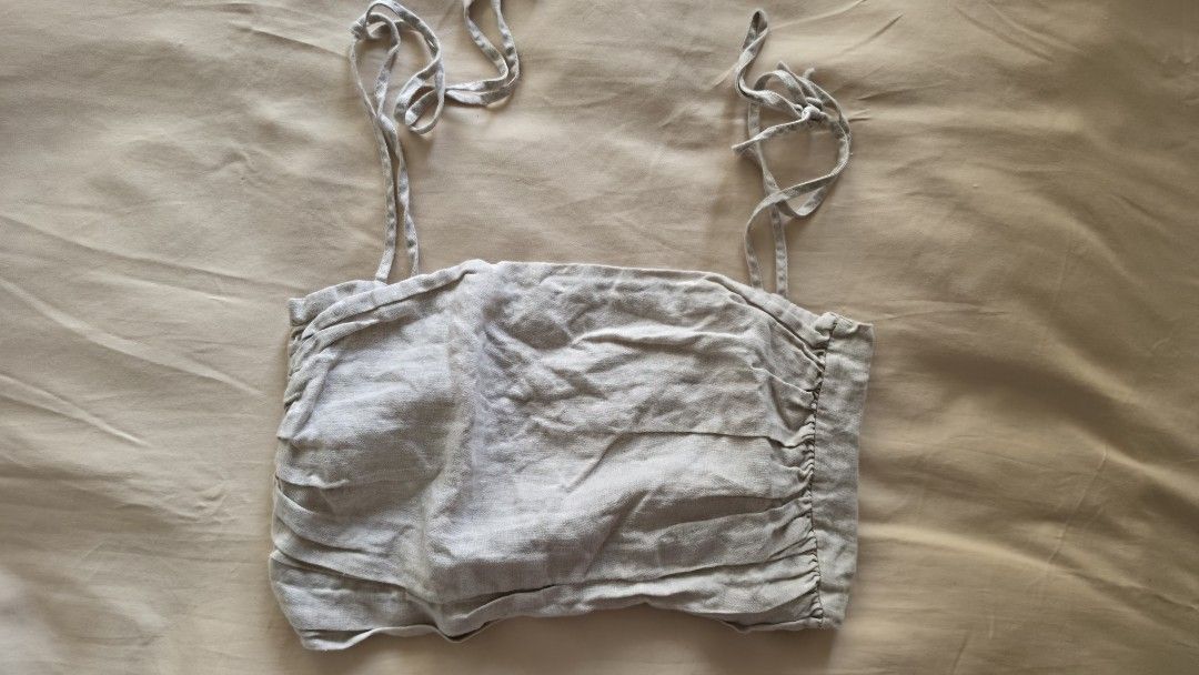 Editor's Market Linen Tie-Strap Crop Top (Category: Sleeveless) located in Manila. Submitted by aclosetsale (Listing ID 1427712581, Image 1). Description: Crop top features tie straps and a ruched front. It has a light, patterned fabric. The top is a neutral color, making it versatile for various outfits. It's a stylish piece for a casual look..
