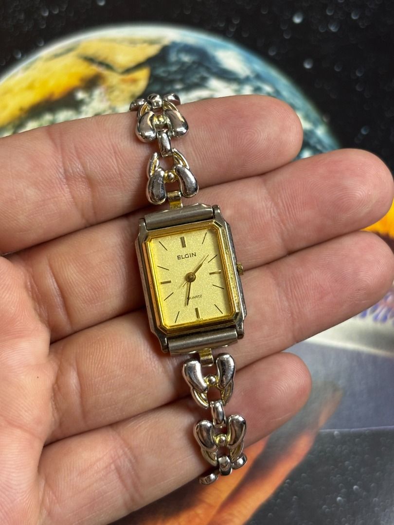 ELGIN RECTANGULAR GOLD – VINTAGE DRESS WATCH (Category: Women's Watches) located in Mandaue City. Submitted by nippon-finds (Listing ID 1427715605, Image 1). Description: Brand/Model: Elgin Quartz Case Size: approx. 20mm Year: 1990s Material: Gold Plated (GP) Details: Rectangular case, gold dial, jewelry-style bracelet Condition: Good, light wear Price: ₱2,000 Meet-up: IT Park Cebu (weekdays), SM JMall Mandaue (weekends) Shipping: Available, ship