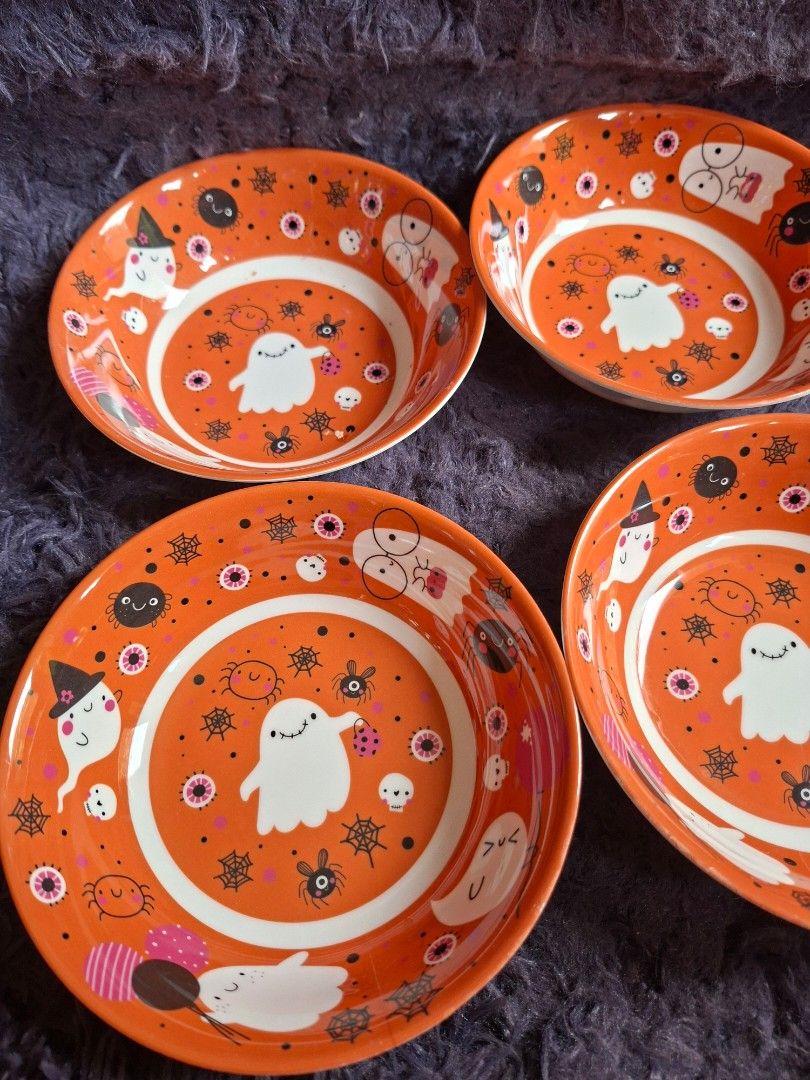 Gourmetable Halloween Bowls Set (Category: Dinnerware & Cutlery) located in Quezon City. Submitted by charsonetrends (Listing ID 1427682970, Image 3). Description: Set of four Gourmetable bowls with a Halloween-themed design. The bowls feature an orange background with white, black, and pink illustrations of ghosts, spiders, and other spooky elements. The bowls are not microwave-safe and BPA-free..