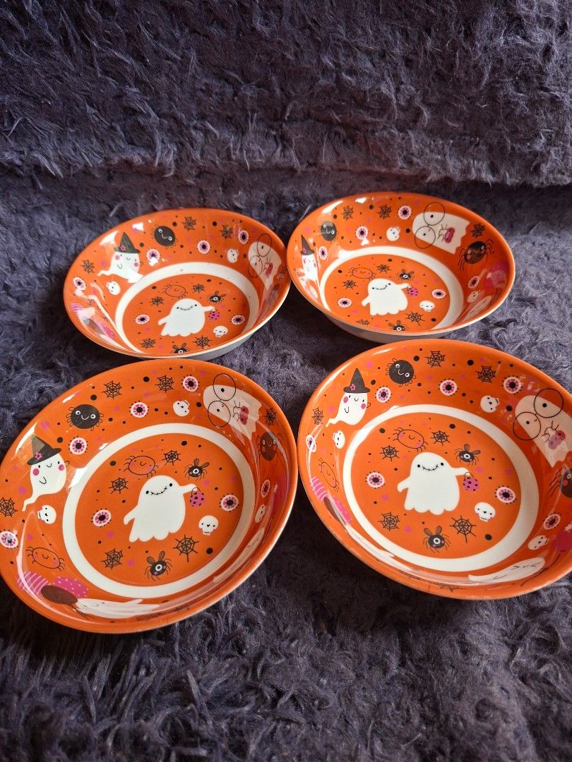 Gourmetable Halloween Bowls Set (Category: Dinnerware & Cutlery) located in Quezon City. Submitted by charsonetrends (Listing ID 1427682970, Image 2). Description: Set of four Gourmetable bowls with a Halloween-themed design. The bowls feature an orange background with white, black, and pink illustrations of ghosts, spiders, and other spooky elements. The bowls are not microwave-safe and BPA-free..