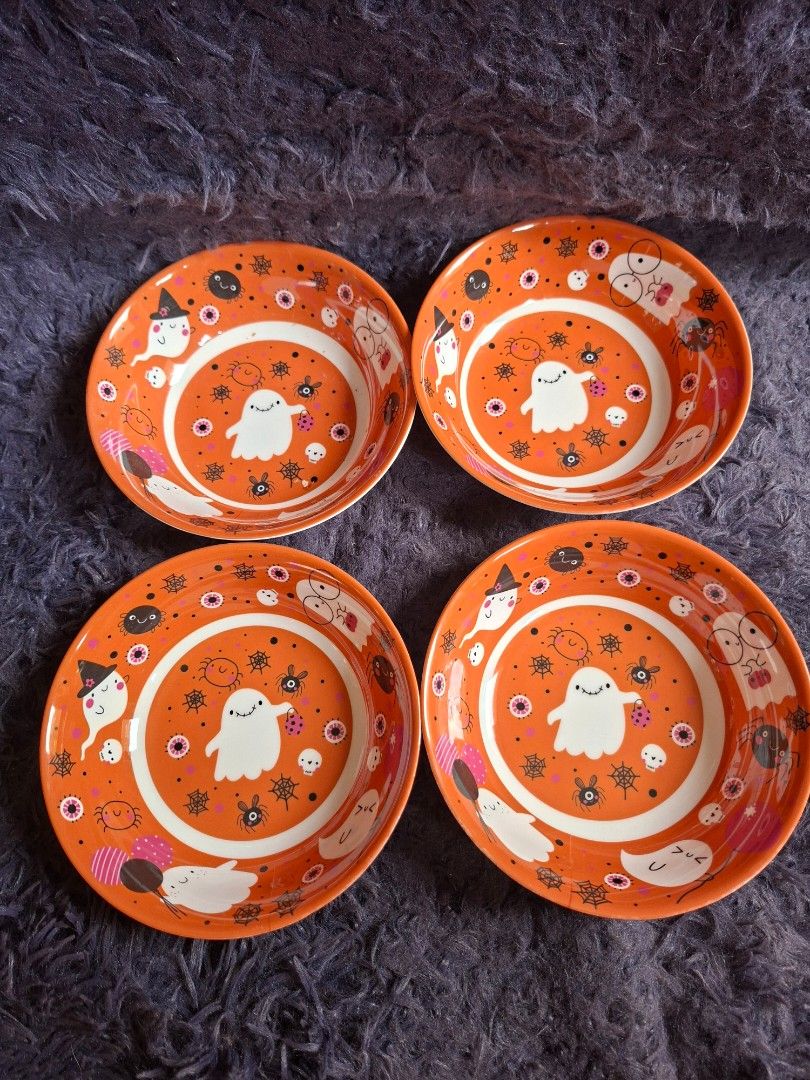 Gourmetable Halloween Bowls Set (Category: Dinnerware & Cutlery) located in Quezon City. Submitted by charsonetrends (Listing ID 1427682970, Image 1). Description: Set of four Gourmetable bowls with a Halloween-themed design. The bowls feature an orange background with white, black, and pink illustrations of ghosts, spiders, and other spooky elements. The bowls are not microwave-safe and BPA-free..