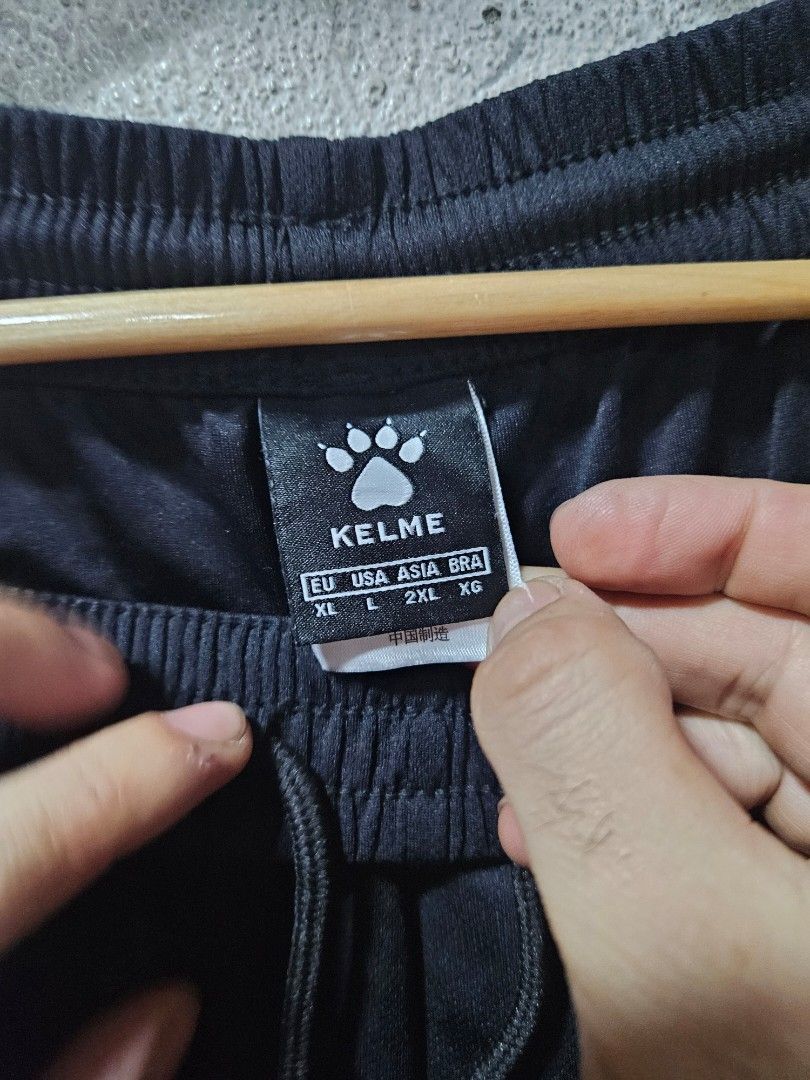 Kelme Black Shorts - XL (Category: Shorts) located in Quezon City. Submitted by itsmeriaa (Listing ID 1427731515, Image 3). Description: Black Kelme shorts with an elastic waistband and drawstring. Features the Kelme logo and the number "6" on the leg. The shorts are size XL, according to the tag. Made in China. The shorts have a paw print logo. DIMES ✔️ W : 30 L : 17.5 Color rate : 10/10 No issue, in excellent cond. ✨️.