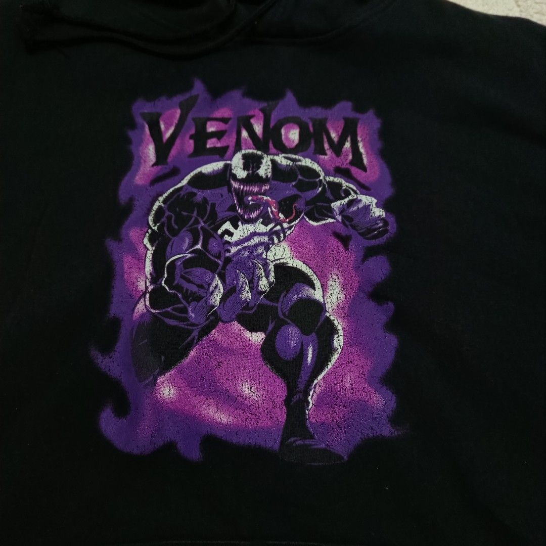 Marvel Venom Hoodie vintage (Category: Hoodies) located in Santa Cruz. Submitted by fiercegem_1ef7ea (Listing ID 1427729541, Image 2). Description: Black hoodie featuring a Venom graphic on the front. The hoodie has a kangaroo pocket and a hood. The Marvel logo is visible on the tag inside the hoodie. Made of a cotton and polyester blend..