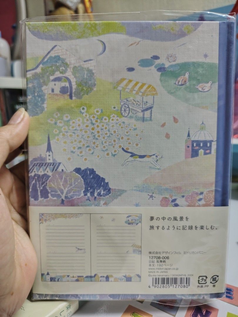 Midori Diary Journal GREEN NA LNG AVAILABLE (Category: Stationery & School Supplies) located in Manila. Submitted by reichellen93323 (Listing ID 1427663083, Image 2). Description: Beautiful Midori diary journal with illustrated covers and pages. Features lined pages with decorative floral and landscape designs. Includes a cover with Japanese text. Perfect for daily journaling or note-taking..