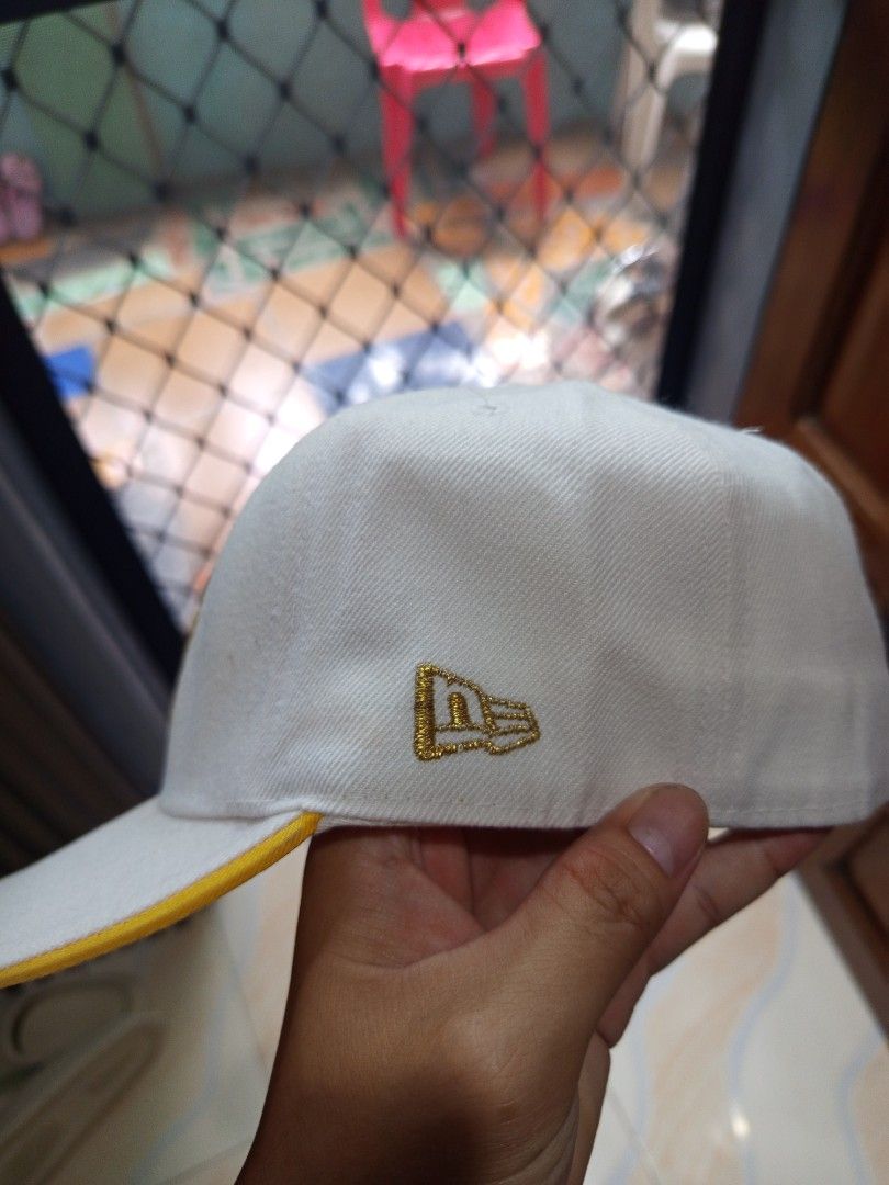 New Era 59FIFTY NY Yankees Cap (Category: Caps & Hats) located in Davao. Submitted by vaness041421 (Listing ID 1427769469, Image 2). Description: New Era 59FIFTY cap features the iconic NY Yankees logo in gold. The cap has a white crown and a yellow brim. The New Era logo is also visible on the side. The interior features the 59FIFTY size tag. A stylish and classic accessory for any Yankees fan..