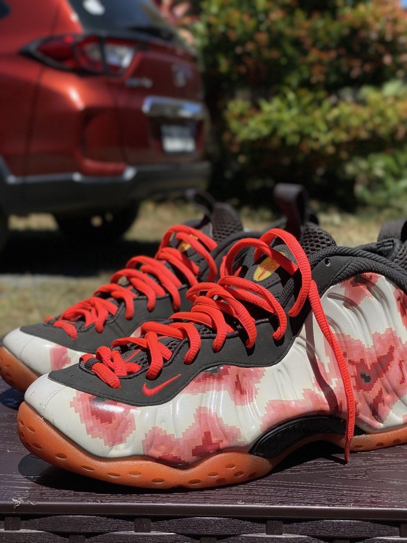 Nike Air Foamposite One Floral (Category: Sneakers) located in Los Banos. Submitted by ejb418 (Listing ID 1427655006, Image 2). Description: Nike Air Foamposite One sneakers with a unique floral design. Features red laces and a black and white upper with a floral pattern. The sole is orange. The size tag indicates a US size 9.5. The shoes have a small hole on the inner side of the shoe. The Nike logo is visible on the tongue and insole..
