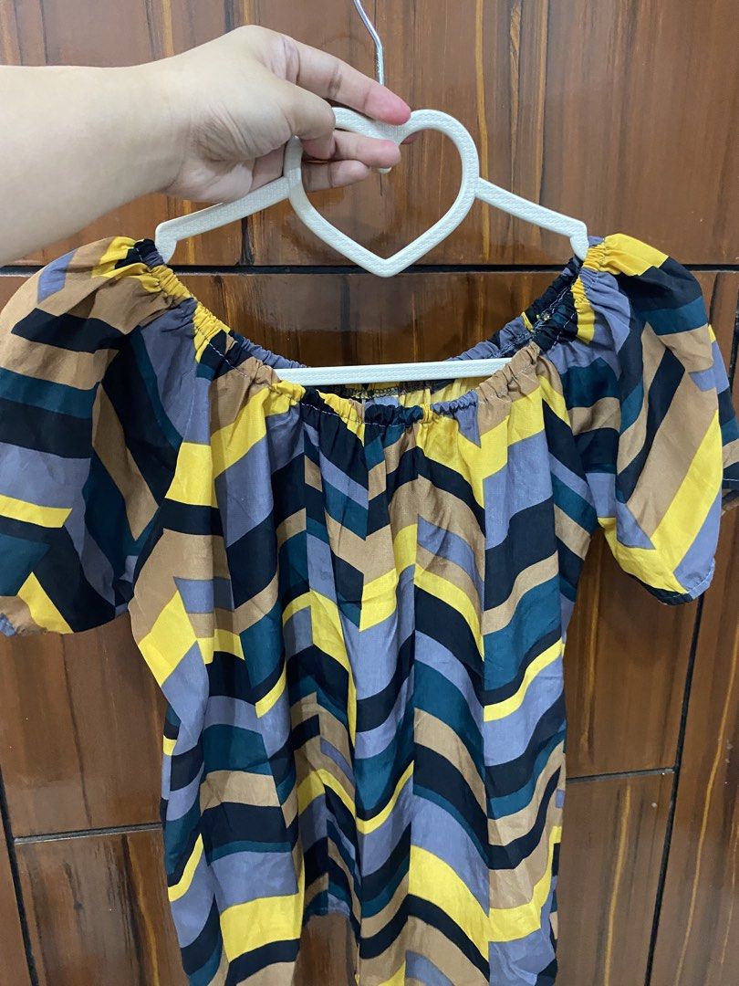 Off-Shoulder Chevron Top (Category: Others Tops) located in Pateros City. Submitted by downsizin (Listing ID 1427647893, Image 2). Description: Stylish off-shoulder top featuring a vibrant chevron pattern in yellow, black, and blue. It has short, puffy sleeves and a comfortable, relaxed fit. The top is designed with an elastic neckline for a secure and flattering look. Perfect for casual outings or adding a pop of color to your wardrobe..