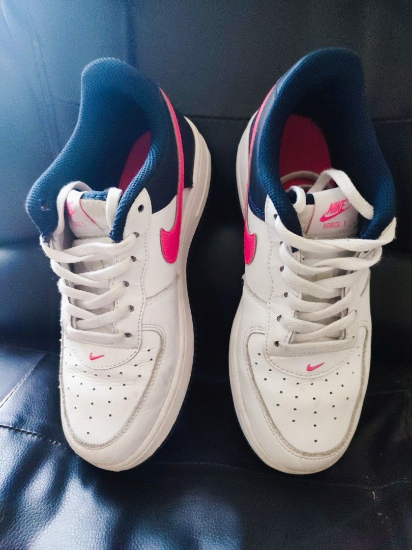 Original Nike Air Force 1 Low White Pink (Category: Babies & Kids Fashion) located in Quezon City. Submitted by PaidTY (Listing ID 1427680487, Image 3). Description: Nike Air Force 1 Low sneakers in white with pink accents. Features a white leather upper with a pink swoosh and a navy blue collar. The Nike logo is visible on the heel and tongue. Includes white laces. Size: US 3, 22 cm rfs: outgrown needs cleaning only.