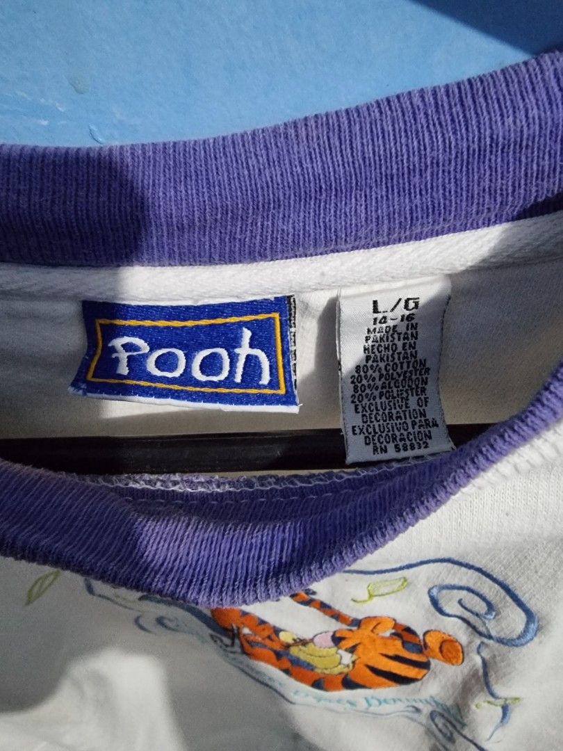 Pooh Tigger Embroidered Sweatshirt L/G (Category: Coats, Jackets and Outerwear) located in Malolos. Submitted by ejaythrift (Listing ID 1427732910, Image 3). Description: Sweatshirt features an embroidered design of Tigger from Winnie the Pooh. It has a purple collar and cuffs. The size is L/G. The sweatshirt is white with a blue and orange design. The Pooh brand tag is visible..