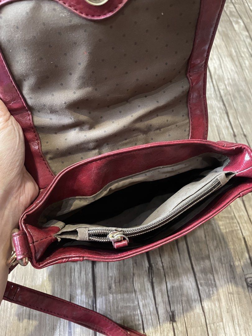 Red Crossbody Bag (Category: Cross-body Bags) located in Pasig City. Submitted by ishyk (Listing ID 1427661297, Image 2). Description: Red 3 way genuine leather bag (crossbody, backpack, shoulder bag) features a flap closure with a gold-tone clasp. It has a single adjustable strap and a top handle. The interior includes a main compartment and a zippered pocket. The bag's exterior has a textured finish..