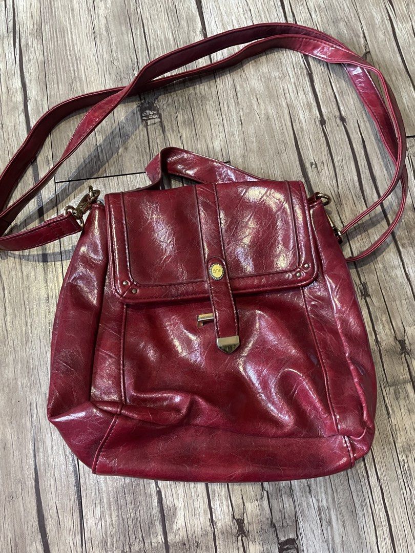 Red Crossbody Bag (Category: Cross-body Bags) located in Pasig City. Submitted by ishyk (Listing ID 1427661297, Image 1). Description: Red 3 way genuine leather bag (crossbody, backpack, shoulder bag) features a flap closure with a gold-tone clasp. It has a single adjustable strap and a top handle. The interior includes a main compartment and a zippered pocket. The bag's exterior has a textured finish..