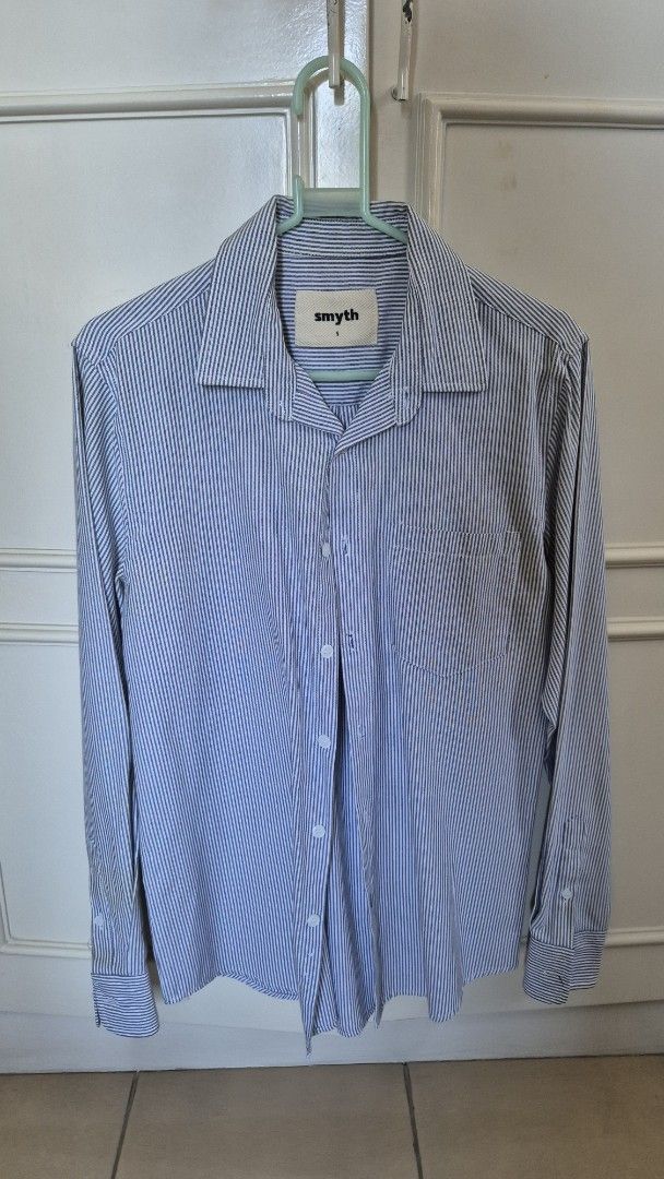 Smyth Striped Shirt - Size S (Category: Tshirts & Polo Shirts ) located in Antipolo. Submitted by declutterinboy (Listing ID 1427661915, Image 1). Description: Shirt features a classic striped pattern in blue and white. It has a collared neckline and long sleeves with buttoned cuffs. The shirt includes a chest pocket and a button-down closure. The brand label is visible inside the collar. It is a size small..