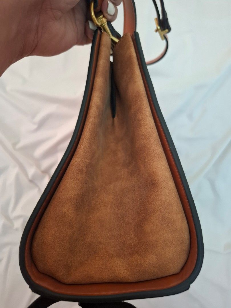 Tory Burch Brown Leather Shoulder Bag (Category: Luxury Bags & Wallets) located in Mandaue City. Submitted by mariah_preloved (Listing ID 1427779305, Image 3). Description: Brown leather shoulder bag with gold-tone hardware. Features a detachable shoulder strap and a flap closure with the Tory Burch logo. The interior has multiple compartments. The bottom of the bag has four protective feet. Some wear is visible on the interior lining. Includes a