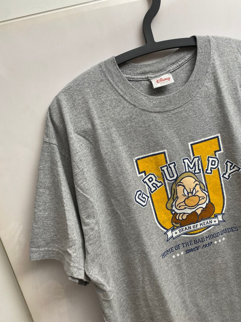 Vintage 90's Disney Grumpy T-shirt (Category: Tshirts & Polo Shirts ) located in Pasig City. Submitted by greatestpickup (Listing ID 1427669887, Image 3). Description: Gray t-shirt featuring Grumpy from Disney's Snow White. The design includes the word "GRUMPY" in a yellow and blue font, along with an image of Grumpy. It also has the text "HOME OF THE BAD MOOD DUDES" and "SINCE 1937". disney grumpy dean of mean 24x31 1000.