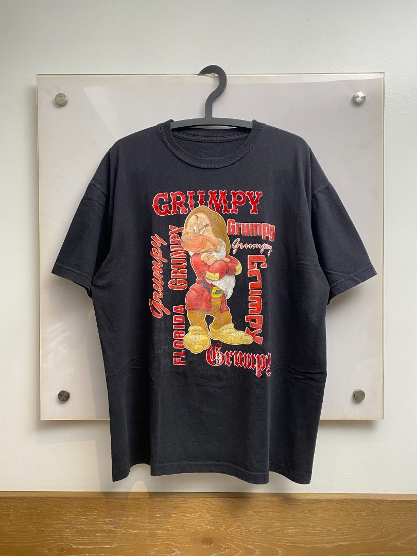 Vintage 90's Disney Grumpy T-shirt (Category: Tshirts & Polo Shirts ) located in Pasig City. Submitted by greatestpickup (Listing ID 1427670899, Image 1). Description: Black t-shirt featuring Grumpy from Disney's Snow White. The design includes the word "Grumpy" in a red font, along with an image of Grumpy. disney grumpy solo red fonts 24.5x30 800.