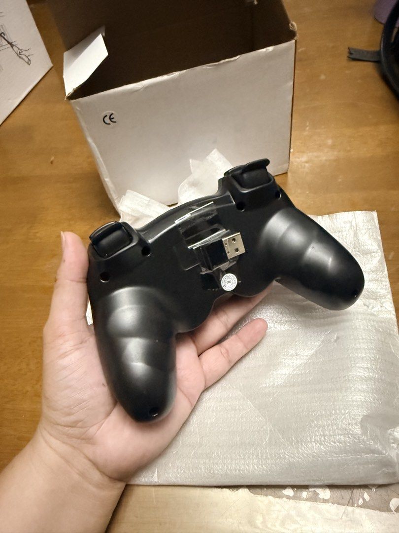 Wireless Game Controller (Category: Controllers) located in Pilar. Submitted by faveanyshop (Listing ID 1427673379, Image 3). Description: Wireless game controller with a black design. Features include a D-pad, action buttons (X, Y, A, B), and dual analog sticks. Includes a USB receiver and a charging port. Comes with its original box..