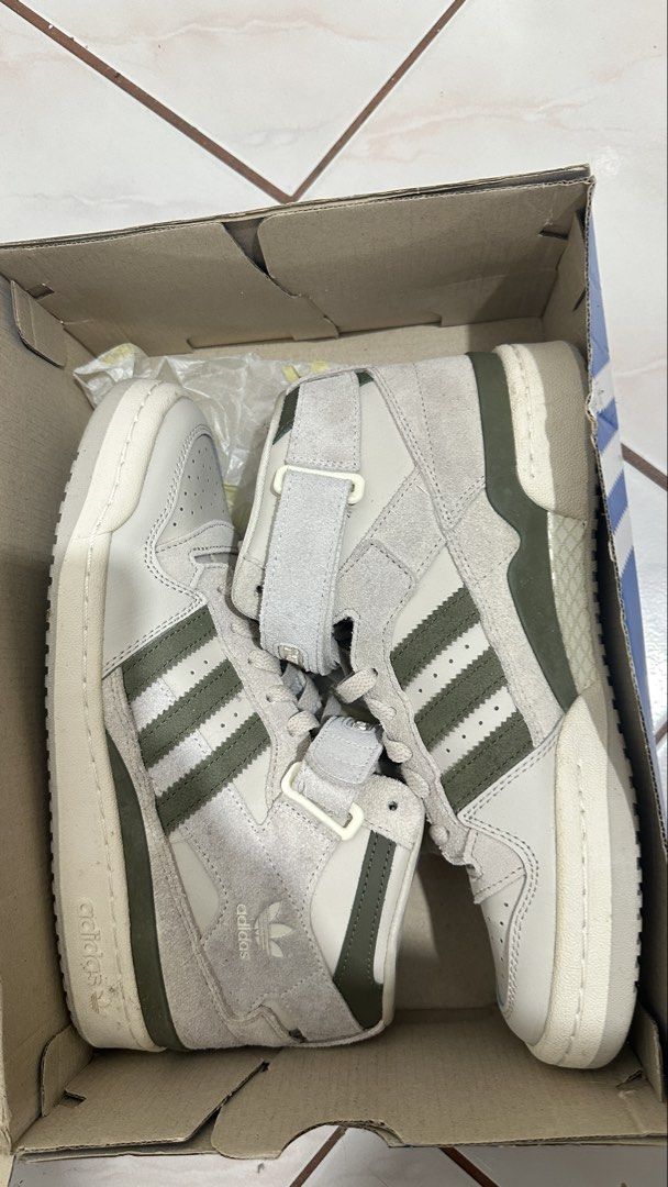 Adidas Forum Mid W GY4869 (Category: Sneakers) located in Antipolo. Submitted by janeymeee760 (Listing ID 1427874148, Image 3). Description: Adidas Forum Mid W sneakers in a neutral colorway with olive green accents. Features a high-top design with a velcro strap. The shoes are in their original box. Size US 9, UK 7.5, EUR 41 1/3, and CHN 260. The original price tag shows S$149.00. Bought in SG. Used once. .