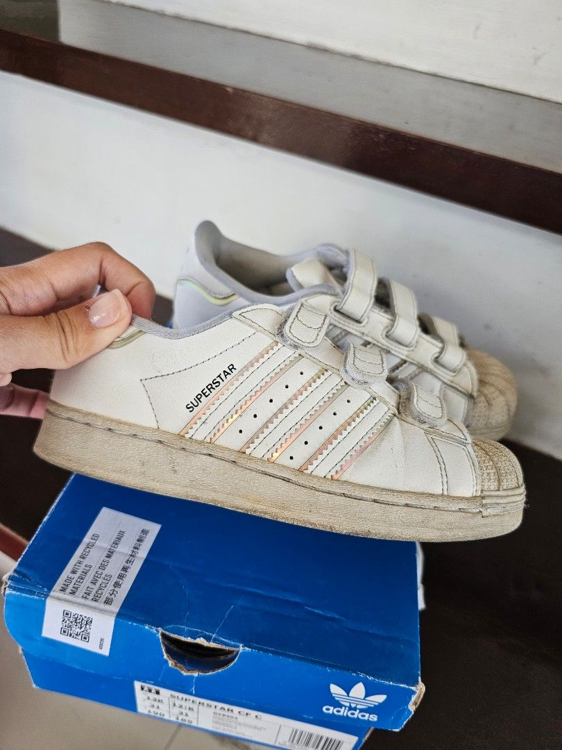 Adidas Superstar Velcro Shoes (Category: Babies & Kids Fashion) located in Imus. Submitted by lanaxalan (Listing ID 1427800261, Image 2). Description: Adidas Superstar CF C velcro shoes. White with three stripes and velcro straps. Includes the original box. Size is US 13K, UK 12K, FR 31, JP 190. The box has some wear and tear. Bought in Adidas Hong Kong. .