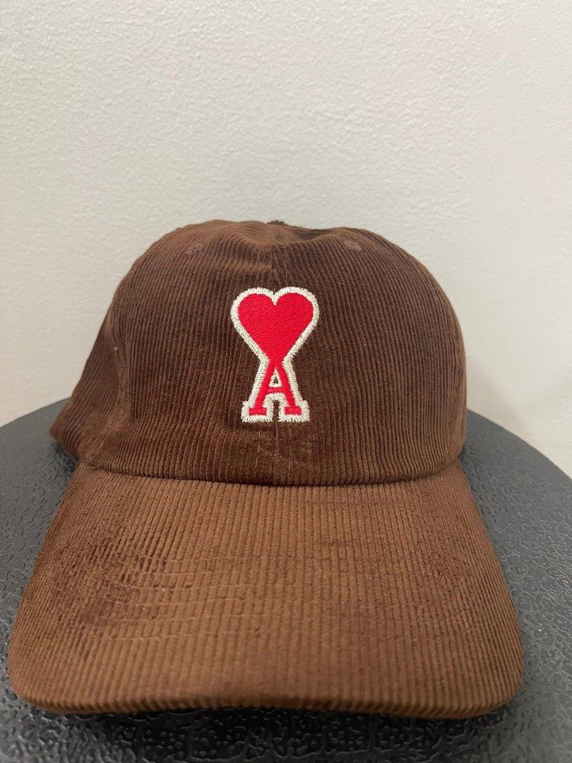 AMI Paris Corduroy Cap (Category: Caps & Hats) located in Las Pinas. Submitted by UNQUARANTINED (Listing ID 1427823621, Image 1). Description: AMI Paris cap features a brown corduroy fabric with the iconic Ami de Coeur logo embroidered on the front. It has a classic baseball cap design with a curved brim. Please note: Payment first before shipping. Courier: LBC only. No meet-ups. Strictly no return, no exchange..
