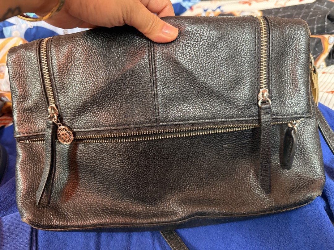 Anne Klein Black Leather Crossbody Bag (Category: Cross-body Bags) located in Manila. Submitted by dangschoice (Listing ID 1427791749, Image 2). Description: Black leather crossbody bag by Anne Klein. Features multiple zippered compartments and a magnetic snap closure. The interior is lined with fabric and includes a small pocket. The bag has a long strap for shoulder or crossbody wear. The Anne Klein logo is visible on the zipper pull and inside