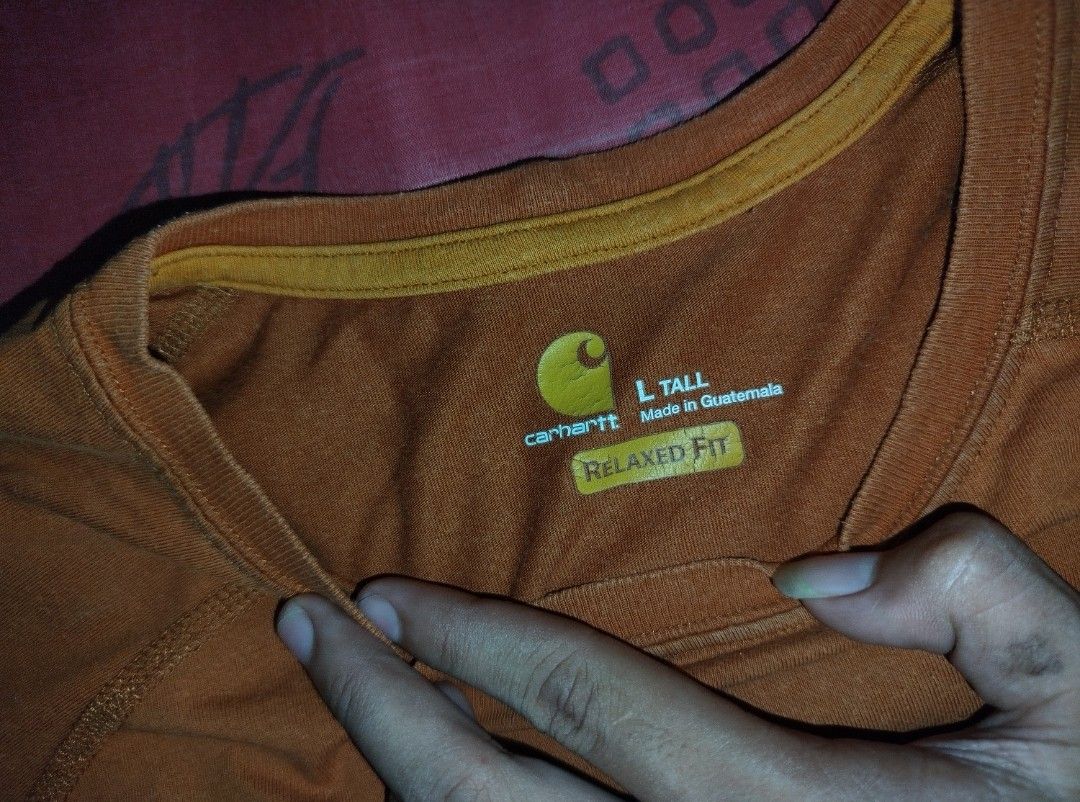 Carhartt Pocket Tee - L Tall (Category: Tshirts & Polo Shirts ) located in Caloocan City. Submitted by vanlemuelv42021 (Listing ID 1427779663, Image 2). Description: Carhartt pocket tee in a brown-orange color. Features a chest pocket with the Carhartt logo. The shirt is a relaxed fit and made in Guatemala. Size is L Tall. The tag indicates it's from the Fall 2020 collection. Made of a cotton-polyester blend..