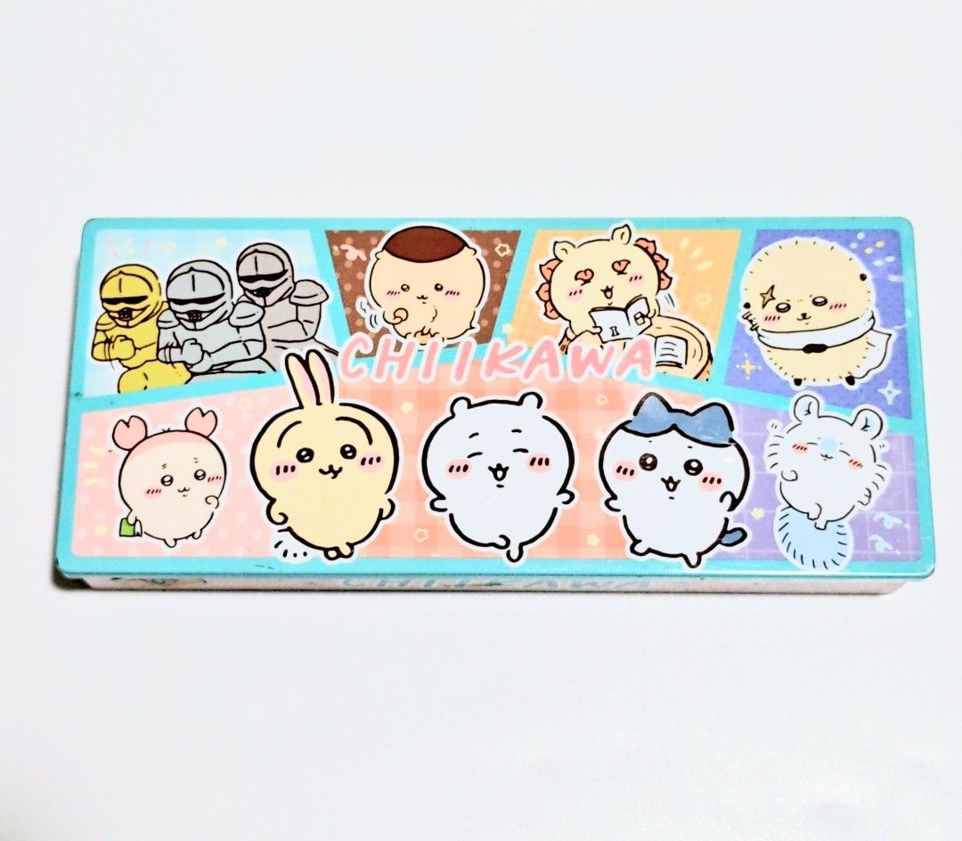 Chikawa Pencil Case (Tin Can) (Category: Stationery & School Supplies) located in Manila. Submitted by yourfavoritethings7 (Listing ID 1427781503, Image 1). Description: Pencil case features a colorful Chikawa design. It has a rectangular shape with a pink lid and a blue base. The case is made of metal. The design includes various Chikawa characters and other illustrations. It is suitable for storing pens, pencils, and other stationery items..