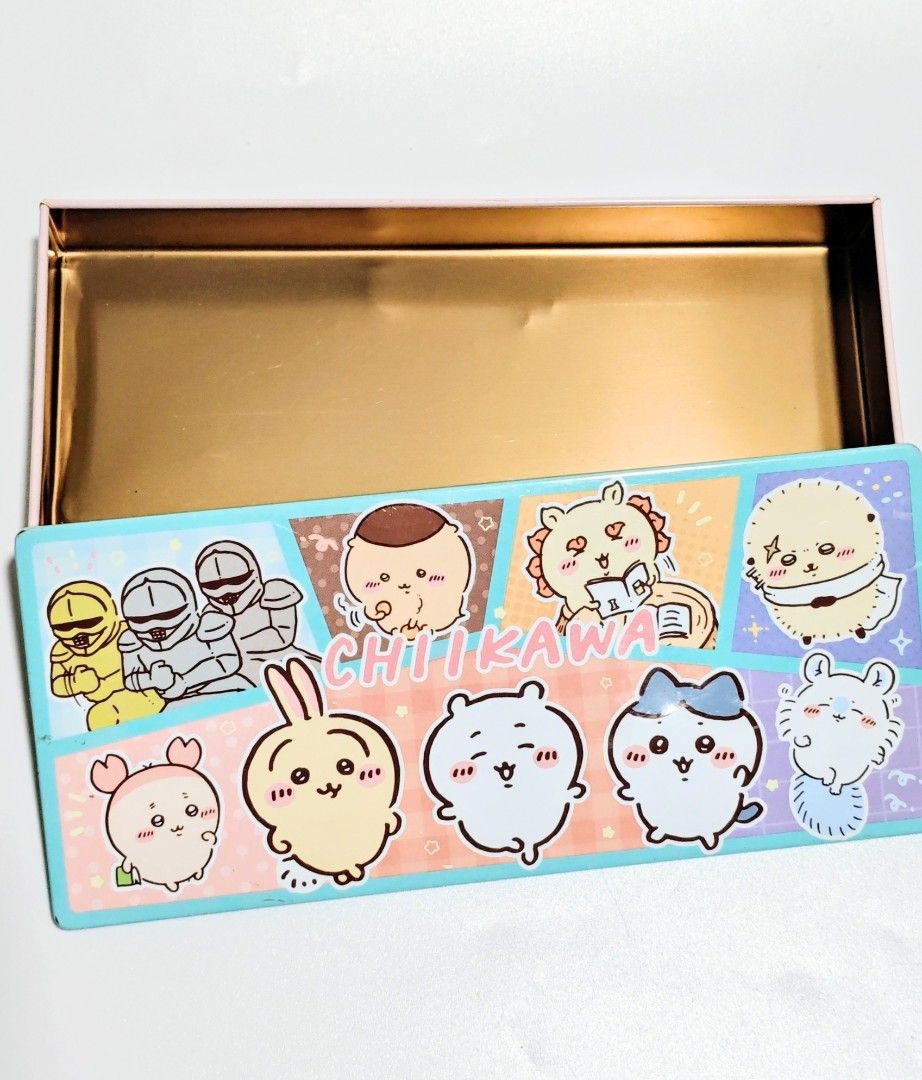 Chikawa Pencil Case (Tin Can) (Category: Stationery & School Supplies) located in Manila. Submitted by yourfavoritethings7 (Listing ID 1427781503, Image 3). Description: Pencil case features a colorful Chikawa design. It has a rectangular shape with a pink lid and a blue base. The case is made of metal. The design includes various Chikawa characters and other illustrations. It is suitable for storing pens, pencils, and other stationery items..