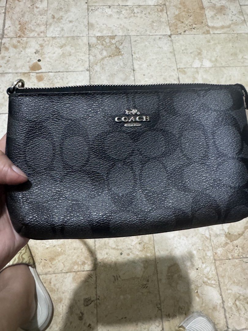 Coach Signature Clutch with Chain (Category: Luxury Bags & Wallets) located in San Juan City. Submitted by idecluttersj (Listing ID 1427906152, Image 1). Description: Black Coach clutch with signature pattern. Features a silver chain strap and a zip closure. The Coach logo is visible on the front of the clutch..