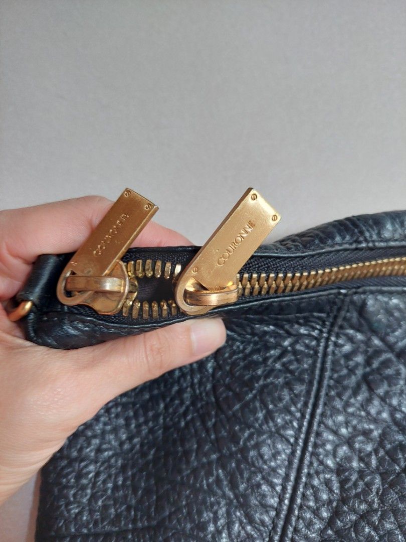 Couronne Black Leather Handbag (Category: Luxury Bags & Wallets) located in Quezon City. Submitted by ayaacinth (Listing ID 1427784181, Image 2). Description: Black leather handbag by Couronne. Features a gold-toned zipper and hardware. The interior includes multiple compartments and a small zippered pocket. The bag has one handle and a rectangular gold-toned plate with the brand name. The bag has a textured leather exterior..