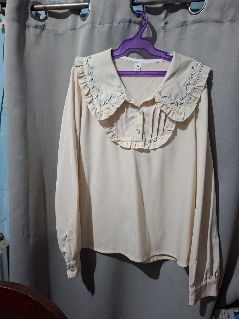 Cream-colored Blouse with Embroidered Sleeves (Category: Blouses) located in Manila. Submitted by eli959 (Listing ID 1427868620, Image 3). Description: Cream-colored blouse with long sleeves. Features delicate blue embroidery along the cuffs and collar. The collar has a ruffled design. Includes button closures on the cuffs and at the neckline..
