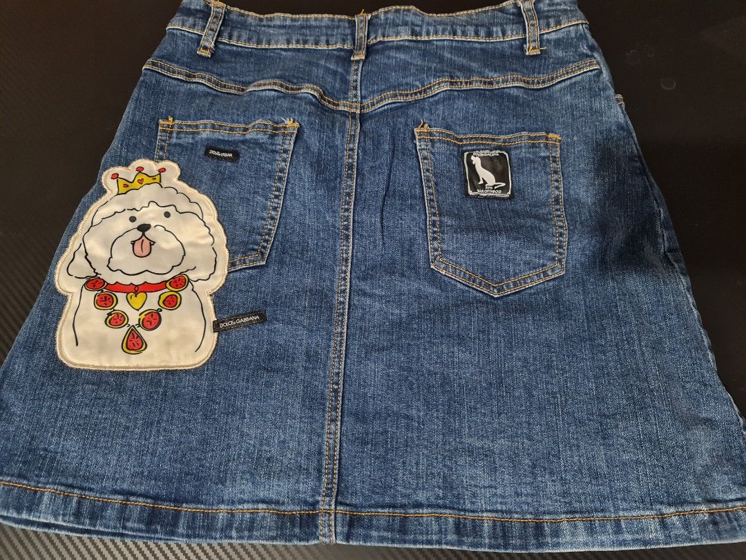 Dolce & Gabbana Denim Skirt (Category: Luxury Apparel) located in Angeles City. Submitted by reallygraceful (Listing ID 1427907226, Image 3). Description: Authentic Dolce & Gabbana Kids denim skirt. Features a unique dog patch design on the front and back. Made in Italy. The skirt has a button and zipper closure. Waist measures approximately 32 inches, and the length is about 17 inches. A stylish and fun piece for any wardrobe..