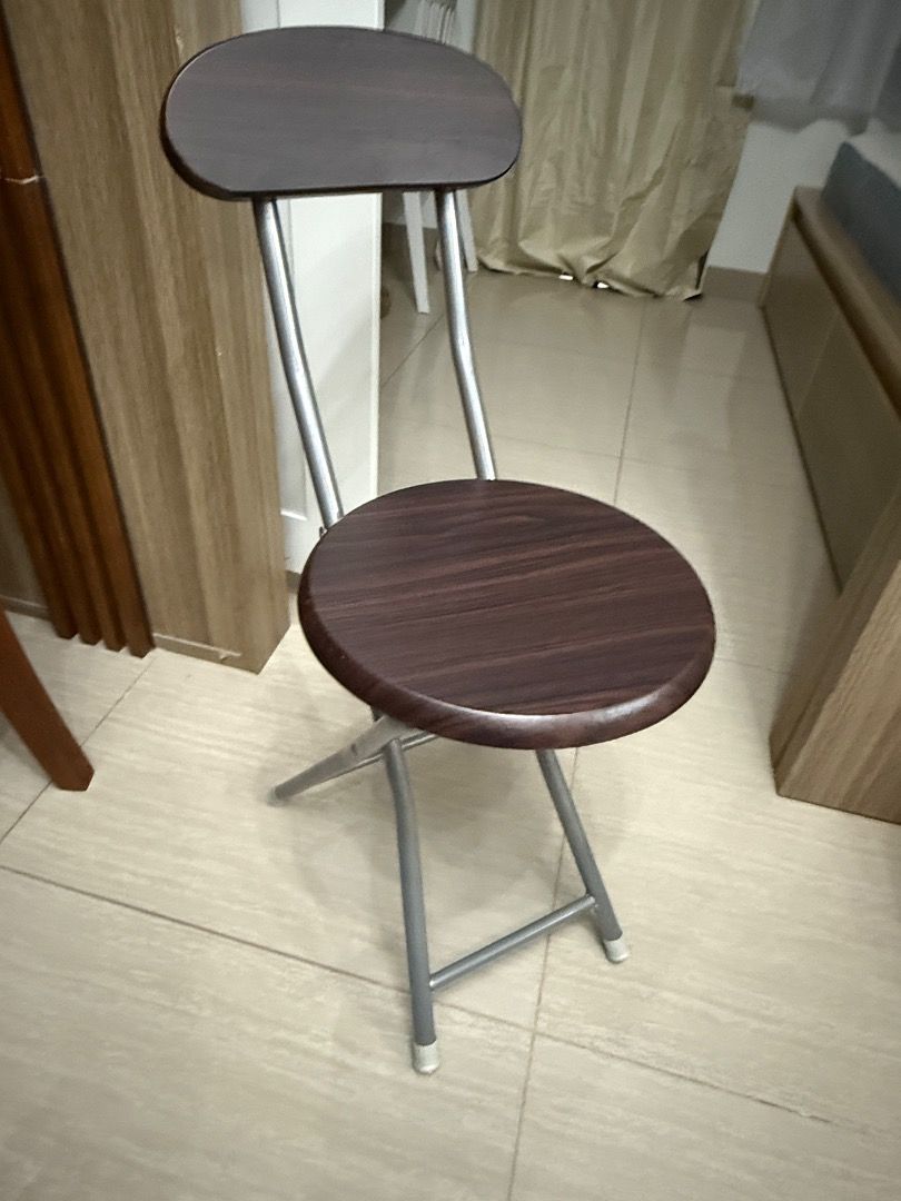 Folding Chair with Backrest (Category: Chairs) located in Tiaong. Submitted by bopeep23 (Listing ID 1427845043, Image 1). Description: Folding chair features a dark brown wooden seat and backrest, supported by a silver metal frame. It has a round seat and a backrest for added comfort. The chair is designed to fold for easy storage and portability. It's a practical seating solution for various settings..