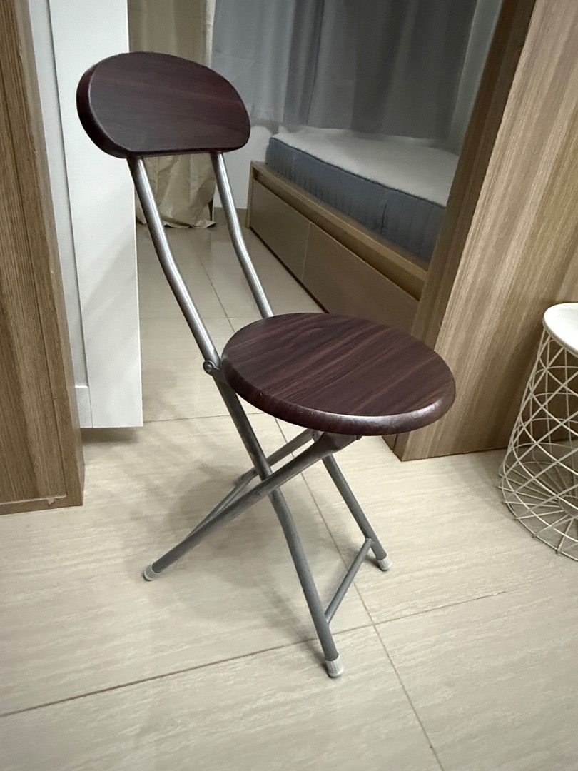 Folding Chair with Backrest (Category: Chairs) located in Tiaong. Submitted by bopeep23 (Listing ID 1427845043, Image 3). Description: Folding chair features a dark brown wooden seat and backrest, supported by a silver metal frame. It has a round seat and a backrest for added comfort. The chair is designed to fold for easy storage and portability. It's a practical seating solution for various settings..