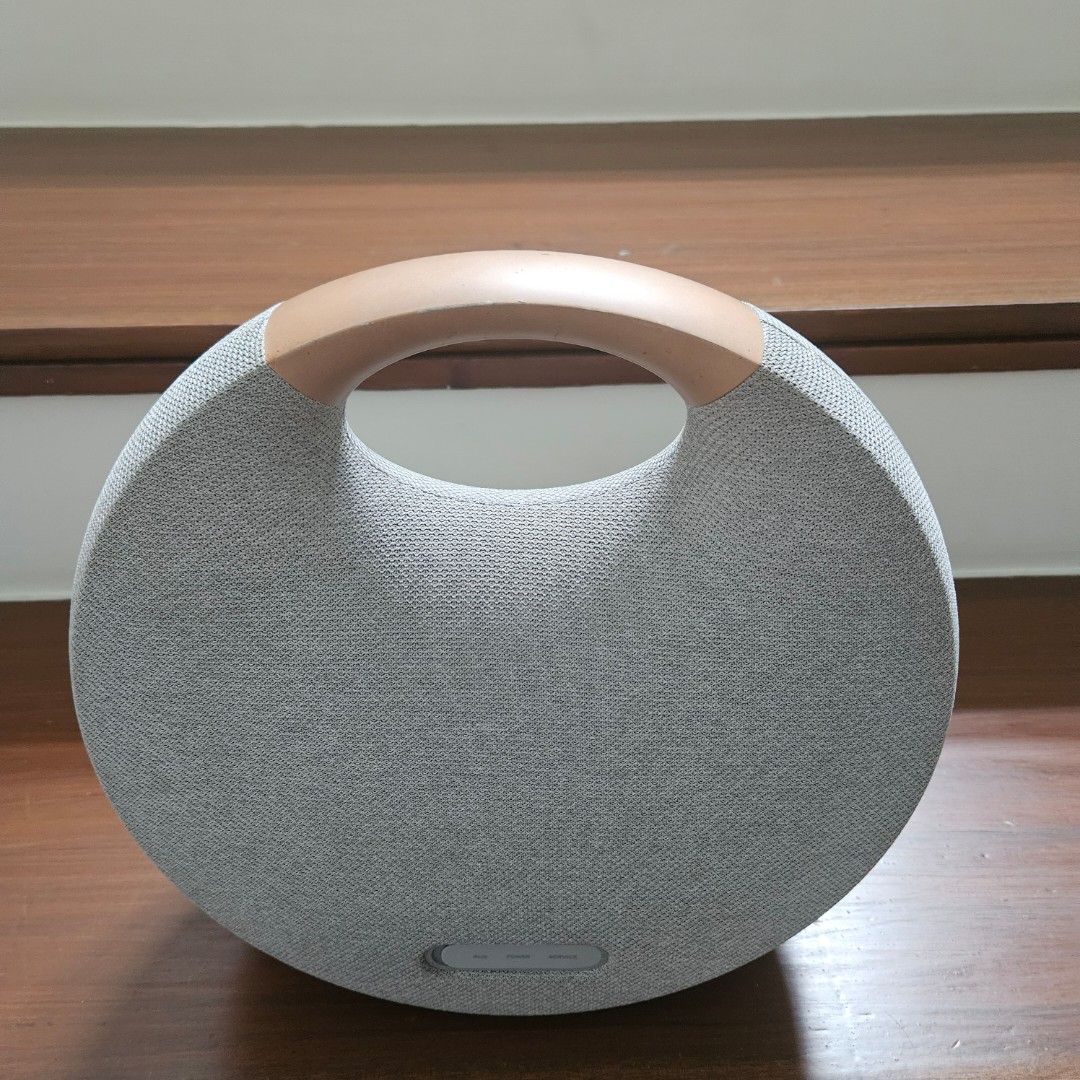 Harman Kardon Onyx Studio 6 Bluetooth Speaker (Category: Soundbars, Speakers & Amplifiers) located in Quezon City. Submitted by madrid212 (Listing ID 1427788467, Image 3). Description: Harman Kardon Onyx Studio 6 is a portable Bluetooth speaker. It has a circular design with a fabric cover and a handle. The speaker has volume controls and a power button. The box is included. The speaker is gray with a wooden handle. won sa Christmas raffle. rfs -