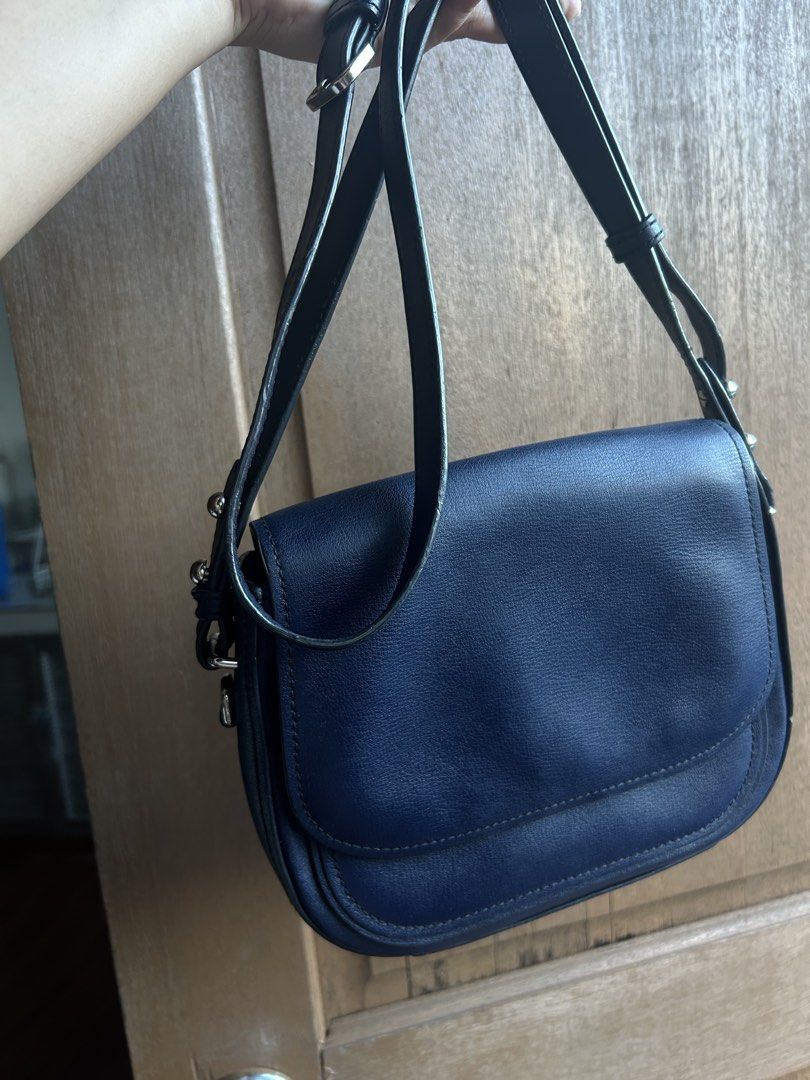 Marc Jacobs Navy Blue Crossbody Bag (Category: Luxury Bags & Wallets) located in Mandaluyong City. Submitted by geri3373 (Listing ID 1427855990, Image 3). Description: Navy blue crossbody bag by Marc Jacobs. Features a flap closure with a magnetic snap. The interior includes a zippered pocket and a slip pocket. The bag has a long adjustable strap. The hardware is silver.