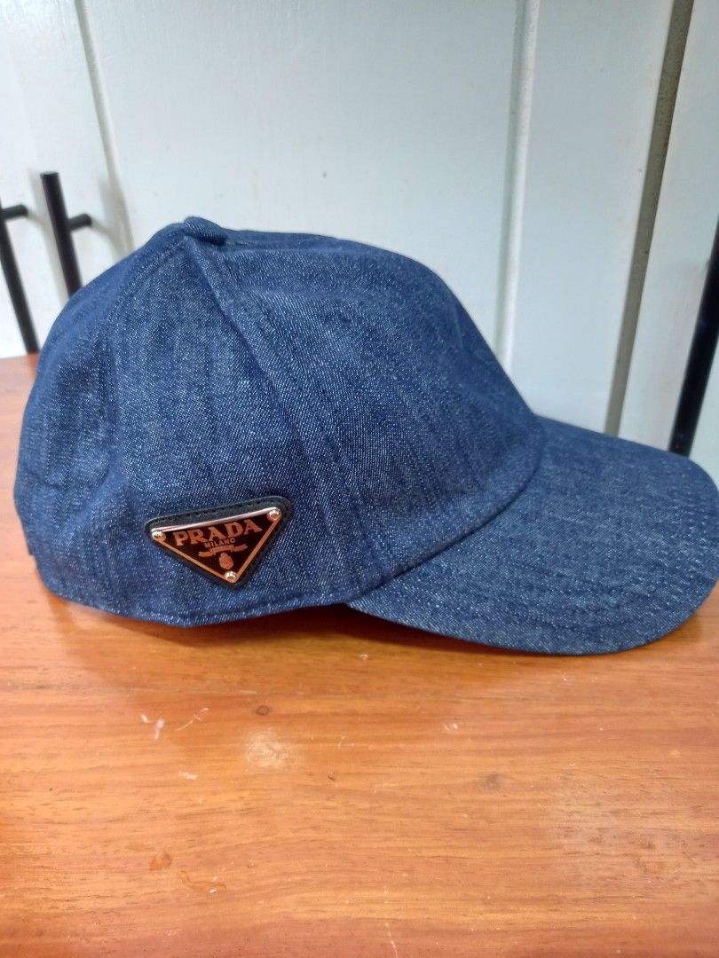 Prada Denim Cap (Category: Caps & Hats) located in Tuguegarao City. Submitted by zenphoenix-7ad615 (Listing ID 1427824854, Image 2). Description: Prada cap in denim. Features the iconic Prada triangle logo on the side. The cap is size M. Made in Italy. The cap has a classic design, suitable for everyday wear. The interior lining is black. The cap is made of polyester. .