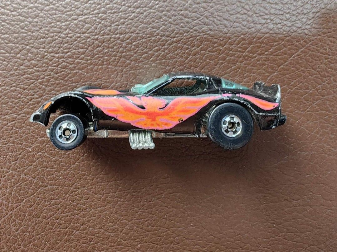 1977 Hot Wheels Black Firebird Funny Car (Category: Vehicle & Diecast Models) located in Quezon City. Submitted by daned05 (Listing ID 1427996475, Image 3). Description: 1977 Hot Wheels Black Firebird Funny Car Vintage Hot Wheels toy car. Features a black body with a flame design in orange and pink. The car has a visible engine and silver wheels. The car's body is separated from the chassis. The car has some wear and tear. Selling as is, where is