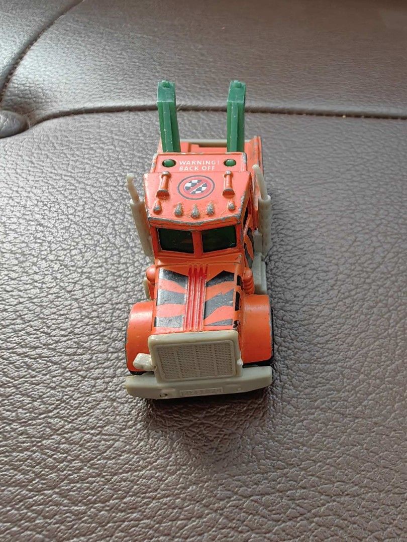 1981 Matchbox Peterbilt Wreck Tow Truck (Category: Vehicle & Diecast Models) located in Quezon City. Submitted by daned05 (Listing ID 1428010359, Image 3). Description: 1981 Matchbox Peterbilt Wreck Tow Truck Vintage Matchbox Peterbilt tow truck. Features an orange cab with black stripes and a green tow arm. The truck has six wheels and a gray chassis. The underside shows the Matchbox and Peterbilt branding, along with the year 1981 and the count