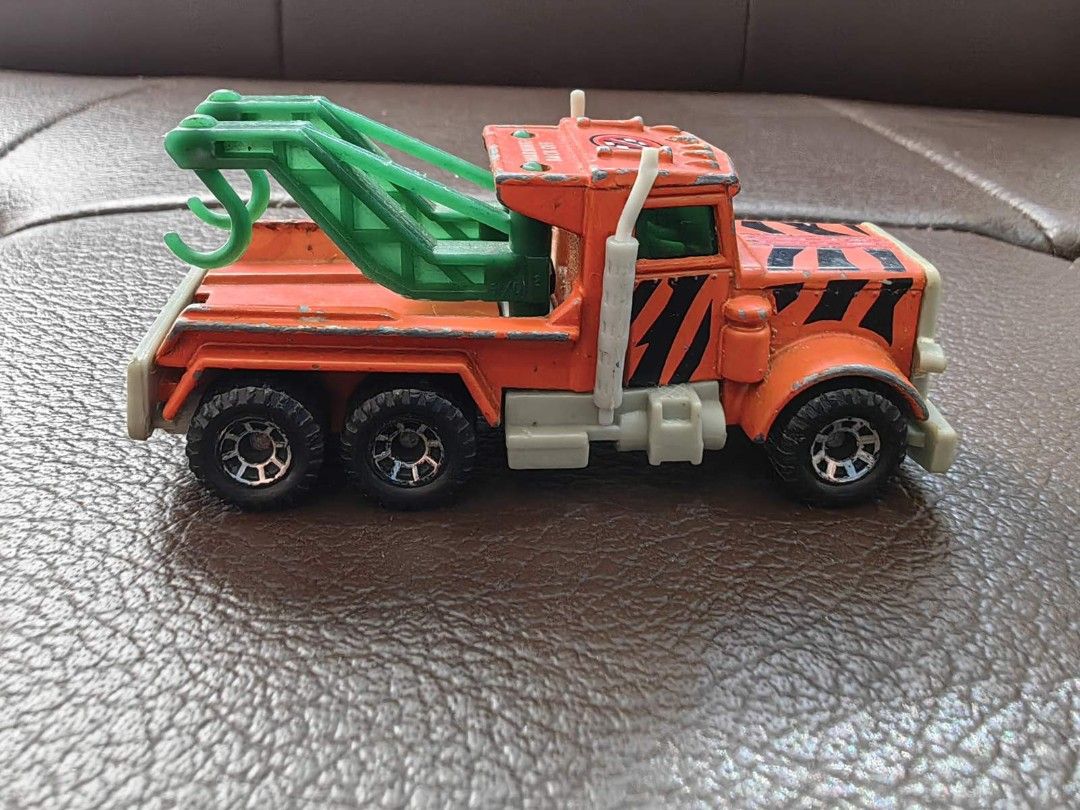 1981 Matchbox Peterbilt Wreck Tow Truck (Category: Vehicle & Diecast Models) located in Quezon City. Submitted by daned05 (Listing ID 1428010359, Image 2). Description: 1981 Matchbox Peterbilt Wreck Tow Truck Vintage Matchbox Peterbilt tow truck. Features an orange cab with black stripes and a green tow arm. The truck has six wheels and a gray chassis. The underside shows the Matchbox and Peterbilt branding, along with the year 1981 and the count