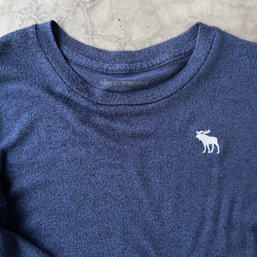Abercrombie Long Sleeve Shirt (Category: Longsleeves) located in Legazpi City. Submitted by tigredest.tropez (Listing ID 1428019307, Image 2). Description: Navy blue long sleeve shirt from Abercrombie. Features the brand name printed on the left sleeve and a small moose logo on the chest. The shirt has a crew neck and a regular fit. Perfect for casual wear. Dimes: 18.5 x 24.