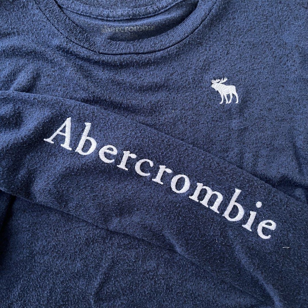 Abercrombie Long Sleeve Shirt (Category: Longsleeves) located in Legazpi City. Submitted by tigredest.tropez (Listing ID 1428019307, Image 3). Description: Navy blue long sleeve shirt from Abercrombie. Features the brand name printed on the left sleeve and a small moose logo on the chest. The shirt has a crew neck and a regular fit. Perfect for casual wear. Dimes: 18.5 x 24.