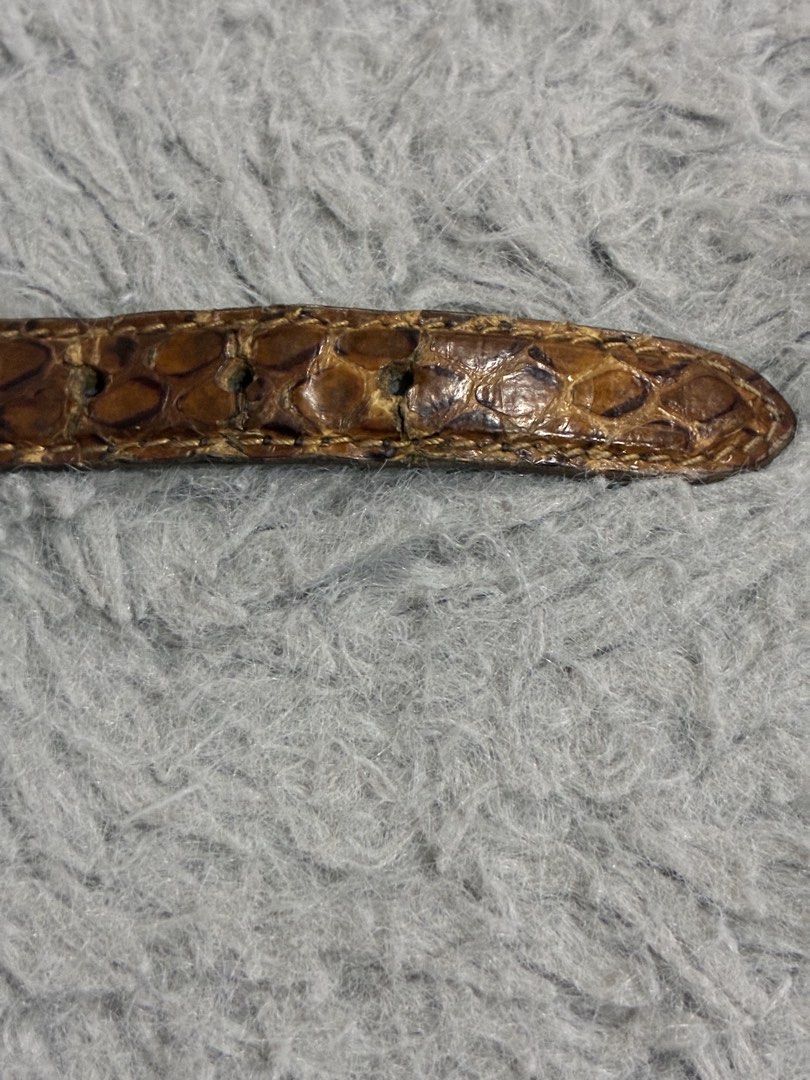 Authentic Prada Snakeskin Bracelet (Category: Luxury Accessories) located in Manila. Submitted by cellymeji060371 (Listing ID 1427964063, Image 3). Description: Authentic Prada bracelet featuring a snakeskin design. The bracelet has a silver buckle and a Prada logo charm. The interior of the bracelet is black leather with the Prada logo embossed. The snakeskin shows some wear and tear. A stylish accessory for any outfit. Has leather cracks, thus 